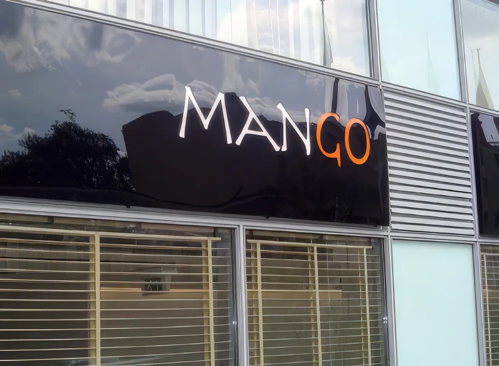 Illuminated Mango restaurant light box on a facade